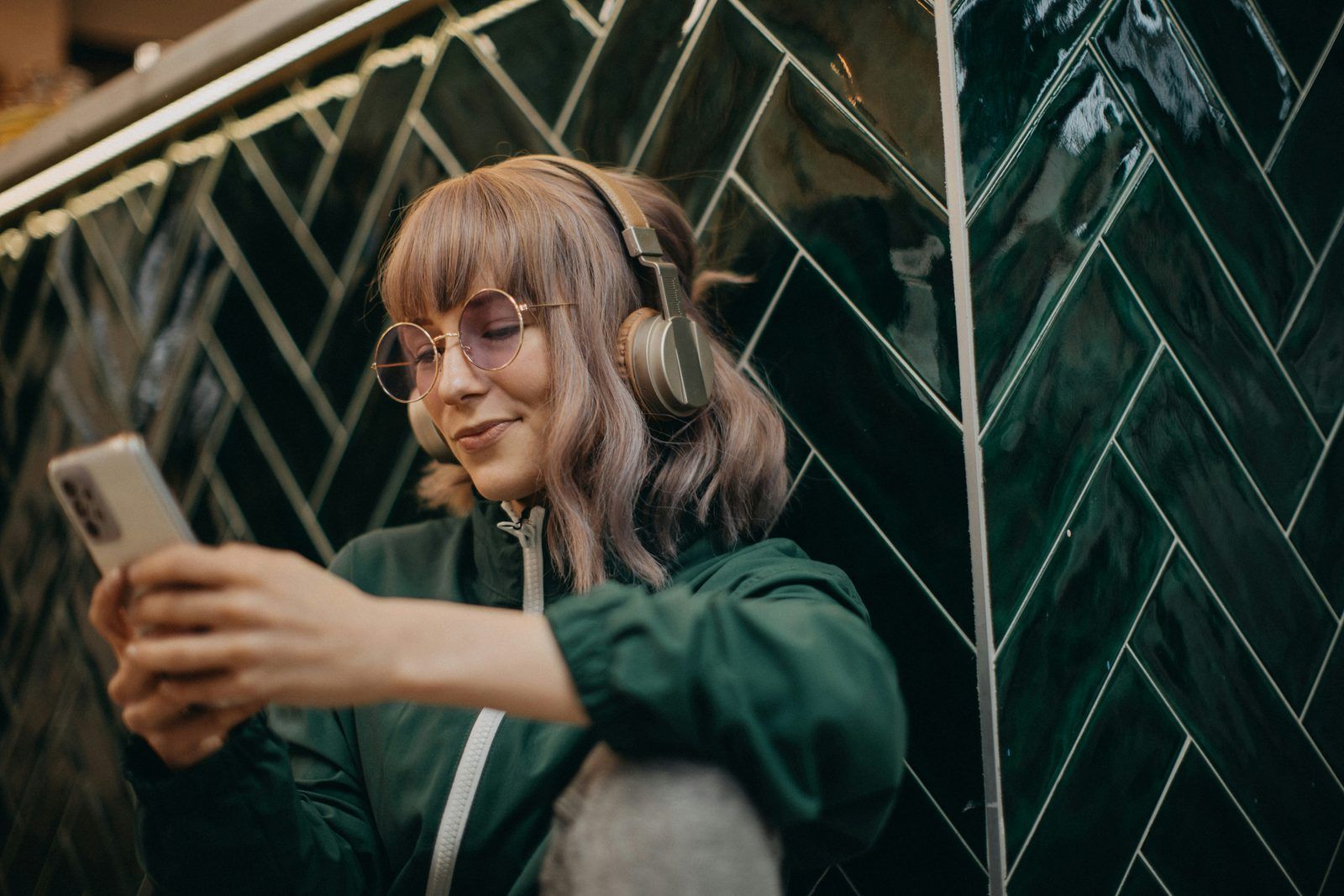 Vrouw met koptelefoon en telefoon luistert naar online audio
